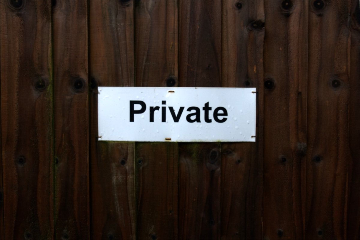 photograph of a dark door with a sign saying Private